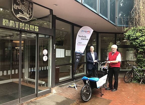 Das Hannah-E-Lastenrad 30 wird an der Ausleihstation direkt vor dem Eingang zum Rathaus in Langenhagen präsentiert vom Langenhagener Bürgermeister Mirko Heuer (links) und vom Sprecher der ADFC-Ortsgruppe Langenhagen Dr. Reinhard Spörer.