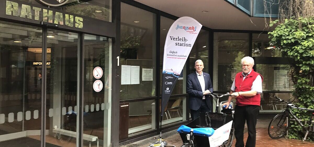 Das Hannah-E-Lastenrad 30 wird an der Ausleihstation direkt vor dem Eingang zum Rathaus in Langenhagen präsentiert vom Langenhagener Bürgermeister Mirko Heuer (links) und vom Sprecher der ADFC-Ortsgruppe Langenhagen Dr. Reinhard Spörer.