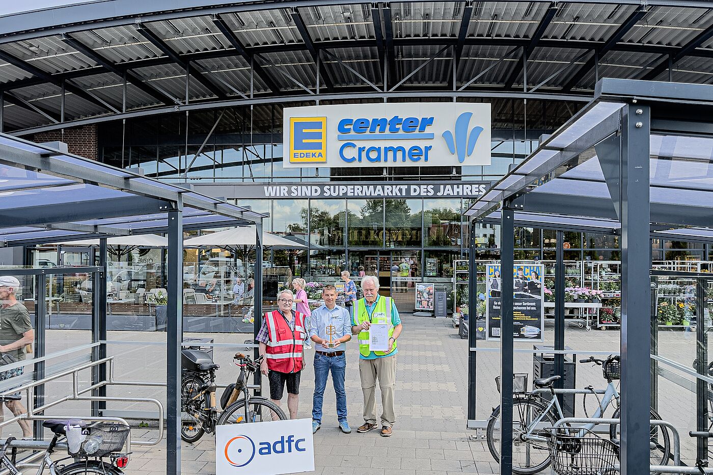 ADFC-Award: Das "Goldene RadPedal 2026" in den Händen von EDEKA-Marktleiter André Fiolek Award gerade übergeben: "Das Goldene RadPedal 2026" in den Händen von EDEKA-Marktleiter André Fiolek, Mitte. Links Reinhard Wolf, rechts Dr. Reinhard Spörer mit der Urkunde, beide ADFC Langenhagen