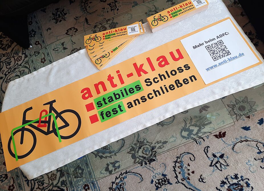 anti-klau4.jpg Das GROßE anti-klau-Plakat liegt fertig auf dem Vorbereitungstisch: Oben zwei Stapel mit den Aufklebern, die im öffentlich zugänglichen Stadtgebiet an Fahrradbügeln aufgeklebt werden / bereits aufgeklebt wurden.