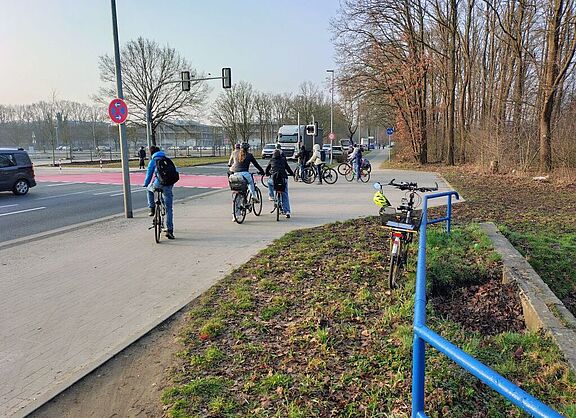 Gymnasium Langenhagen: Zu dieser Ampel fahren Radfahrende auf dem Weg zur Schule. - Bei dieser Momentaufnahme: Zwei der Radfahrenden kamen über den Weg südlich der Kleingärten "Rennbahnblick", die anderen kamen entlang der Theodor-Heus-Straße, also aus Richtung Bäcker Raute
