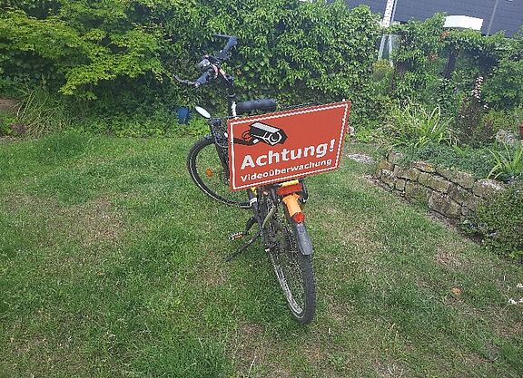 Fahrrad mit Hinweis auf Schild zur Videoüberwachung