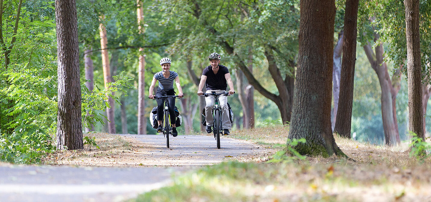 Zwei Radfahrende auf ländlichem Radweg